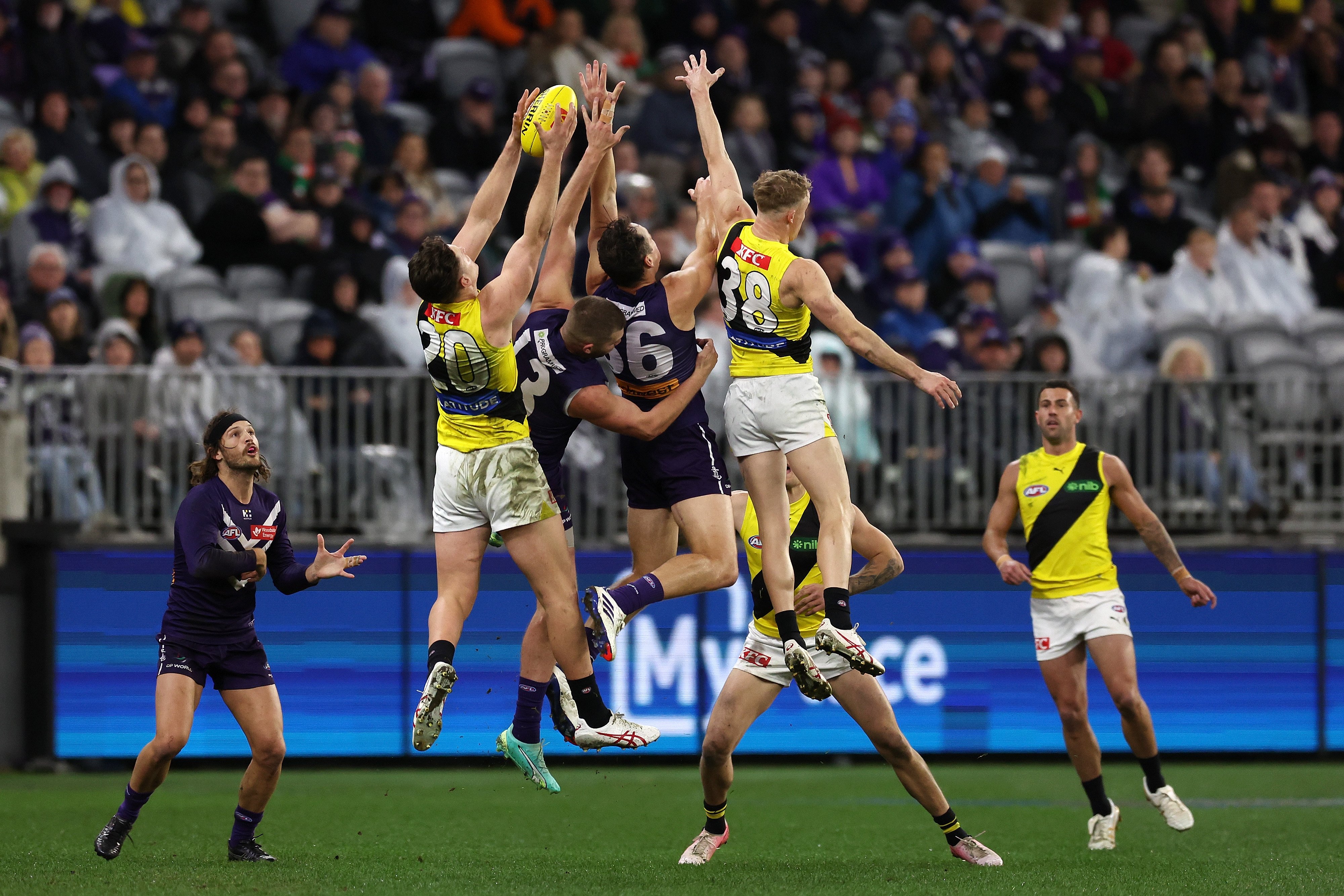 richmond and fremantle dockers afl players reach for the ball mid-air 