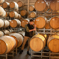 Man sniffing wine surrounded by stacked barrels of wine in the Coonawarra on the Limestone Coast