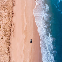 A long stretch of sand dunes with a stretch of fresh water on one side and the sea on the other