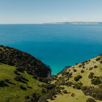 View between two hills from Dudley Wines on Kangaroo Island out over blue seas to the mainland 